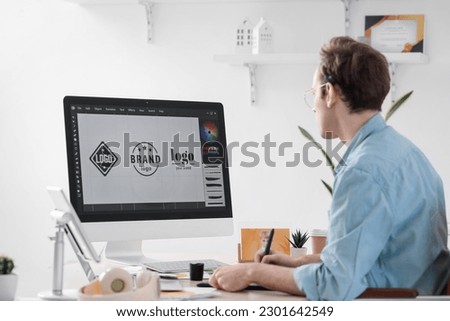 Male graphic designer developing logotype in office Royalty-Free Stock Photo #2301642549