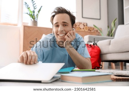 Male student with laptop preparing for exam at home