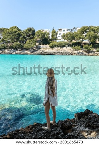 Rear view of blonde woman in cala d'or, cala Gran mallorca, balearic islands Royalty-Free Stock Photo #2301665473