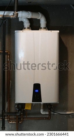 Tankless water heater installed in a home for energy efficiency.                                Royalty-Free Stock Photo #2301666441