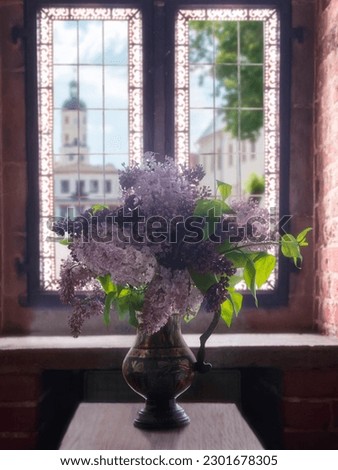 Still life with bouquet of lilac near the window