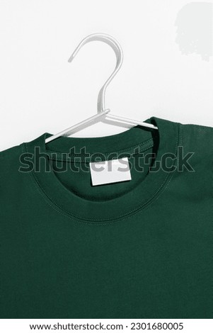 Green t-shirt on a clothes rack. Ecology concept. Mockup.