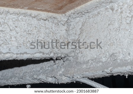 Photo of spray-on asbestos insulation above cealing. Royalty-Free Stock Photo #2301683887