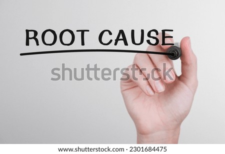 Womans hand writing word Root cause with marker