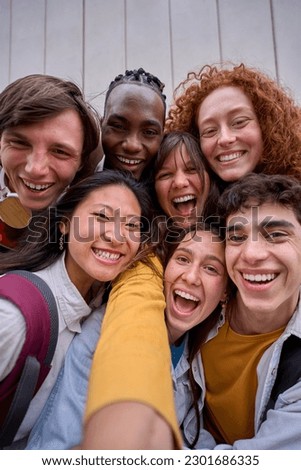 Vertical cell phone selfie of excited multiracial group of erasmus college students together outside. Cheerful smiling young friends pose laughing for photo. Happy people on campus. Royalty-Free Stock Photo #2301686335