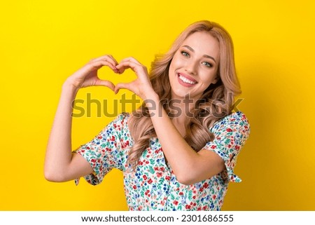 Portrait of cheerful stunning cute kind lady dressed stylish clothes two arms make heart symbol isolated on yellow color background