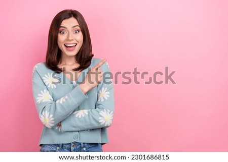 Photo of shocked cute lady direct finger empty space advertise novelty product wear print cardigan isolated pink color background