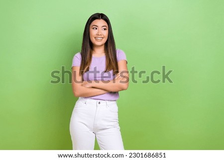 Photo of attractive japanese korean young woman crossed arms look empty space wear trendy purple clothes isolated on green color background