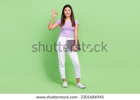 Full body photo of freelancer 3d designer working chinese girl hold laptop show okey sign good job isolated on green color background