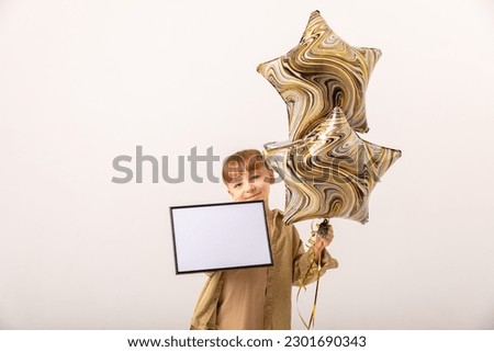 Portrait of cheerful boy holding air balloons isolated on white background. Kids Birthday party concept. Happy Birthday banner with copy space. Studio shot. Mock up