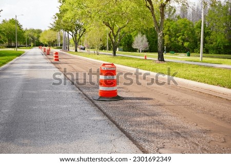 Work on road. Construction cone. Traffic cone, with white and orange stripes on asphalt. Street and traffic signs for signaling. Road maintenance, under construction sign and traffic cone on road