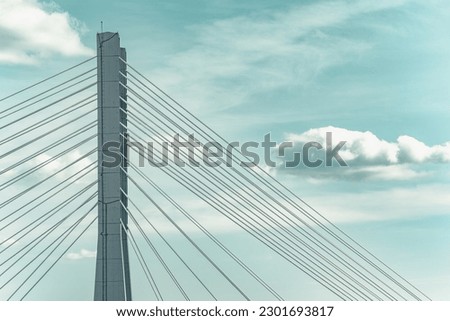 Close up detail with a cable stayed suspension bridge against the blue sky Royalty-Free Stock Photo #2301693817
