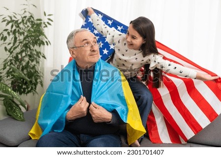 grandfather and granddaughter with the flags of the USA and Ukraine