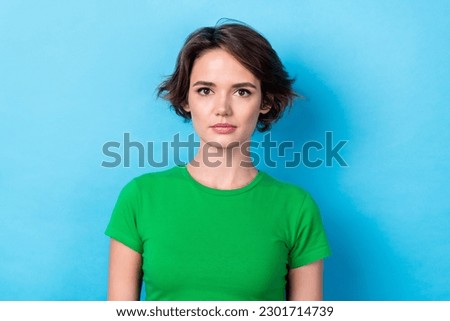 Photo of adorable serious confident woman dressed green t-shirt isolated blue color background