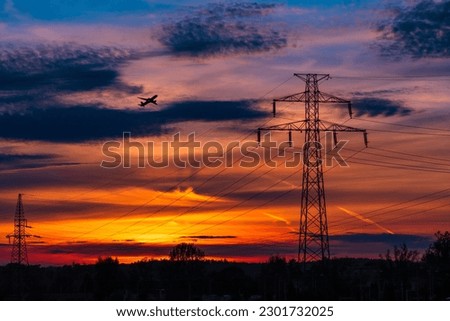 Airplane flying over power lines at sunset, anthropomorphic silhouette, industrial photography, golden hour photo, electric poles and wires, pulsing energy, beautiful sky after sunset