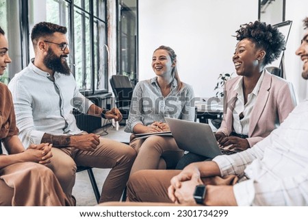 A diverse, casual business team collaborates in the office, brainstorming and creating innovative solutions and fostering in dynamic creative environment. Royalty-Free Stock Photo #2301734299