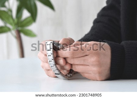 Man's hand and wristwatch on white table Royalty-Free Stock Photo #2301748905