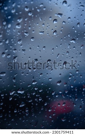 Close-up raindrops falling on the glass Royalty-Free Stock Photo #2301759411
