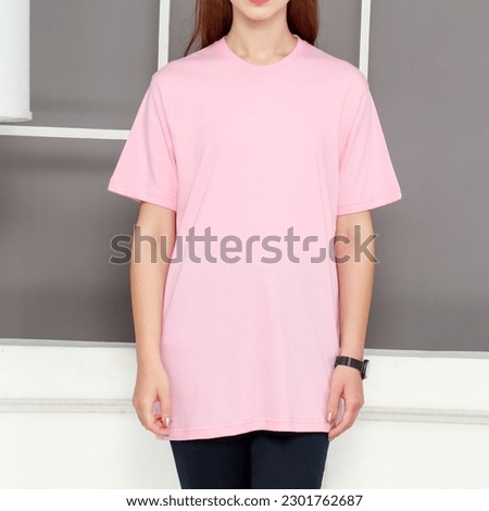 Asian female model wearing multicolored short sleeve t-shirt. Indoor concept, no face photography. Product catalogue for fashion business.