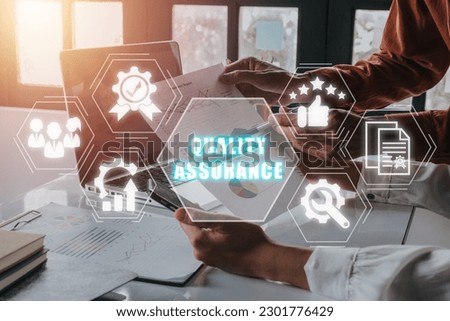 Quality Assurance concept, Business team working on laptop computer and analyzing finance data on office desk with Quality Assurance icon on virtual screen.