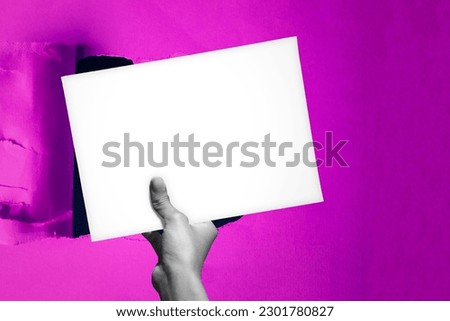 Blank empty paper in man hand covering up a hole in the background