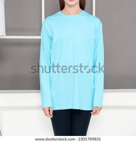 Asian female model wearing multicolored long sleeve t-shirt. Indoor concept, no face photography. Product catalogue for fashion business.