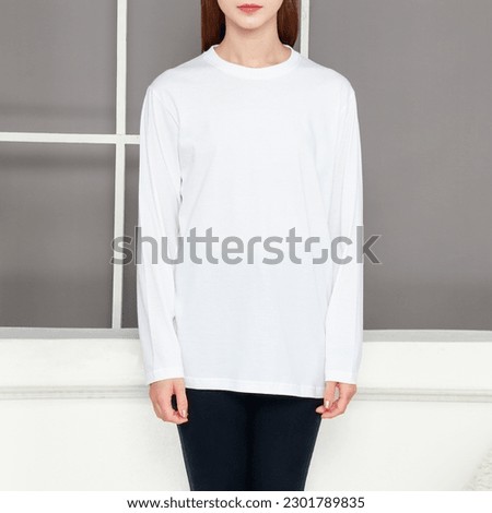 Asian female model wearing multicolored long sleeve t-shirt. Indoor concept, no face photography. Product catalogue for fashion business.