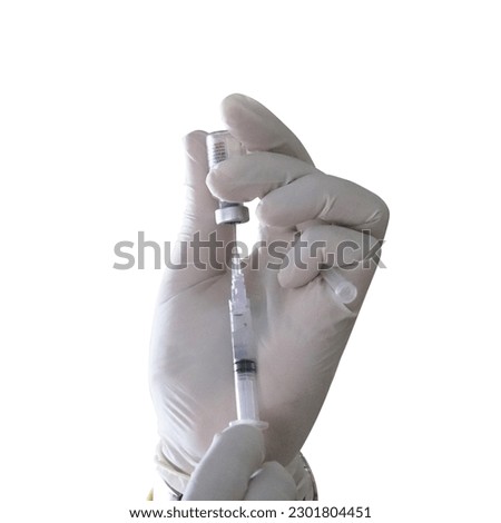 	
A gloved doctor holds a syringe which he fills with medication