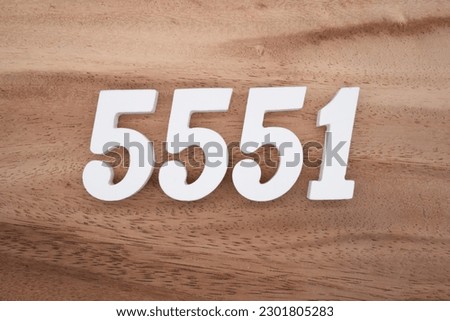 White number 5551 on a brown and light brown wooden background.