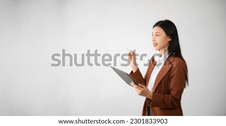 Portrait photo of young beautiful Asian woman feeling happy and holding smart phone, tablet and laptop with black empty screen on white background can use for advertising or product concept.
