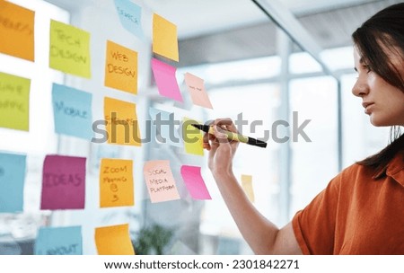 Woman writing notes, brainstorming with ideas on glass board and sticky note, planning in office with focus. Creative project, agenda and female employee working, strategy and storyboard with goals Royalty-Free Stock Photo #2301842271