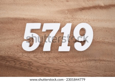 White number 5719 on a brown and light brown wooden background.