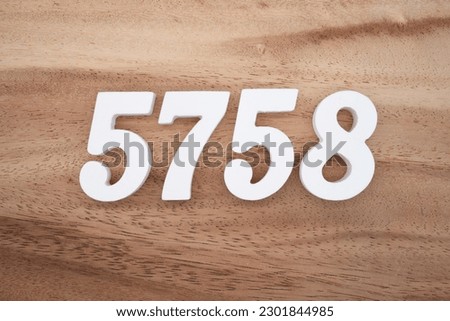 White number 5758 on a brown and light brown wooden background.