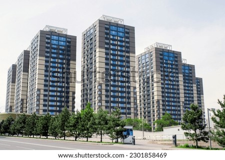 Residential complex with few similar buildings and the road on the foreground. Human ant-hill consisting of several similar modern residential buildings. Complex also called the humant hill in Almaty Royalty-Free Stock Photo #2301858469