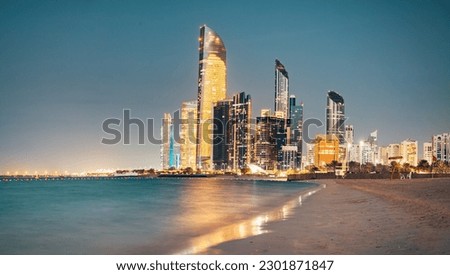 Stunning sandy beach near Corniche seaside embankment with great night view of Abu Dhabi, UAE towering skyscrapers Royalty-Free Stock Photo #2301871847