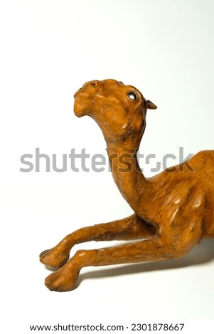 brown toy camel on a white background. desert animal camel synonymous with Islam