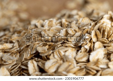 Poured a large amount of oat flakes close-up, background of raw uncooked oatmeal Royalty-Free Stock Photo #2301906777