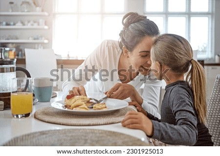 Mother, child and pancakes for breakfast in a family home with love, care and happiness at a table. A happy woman and girl kid eating food in plate together in morning for health and wellness Royalty-Free Stock Photo #2301925013