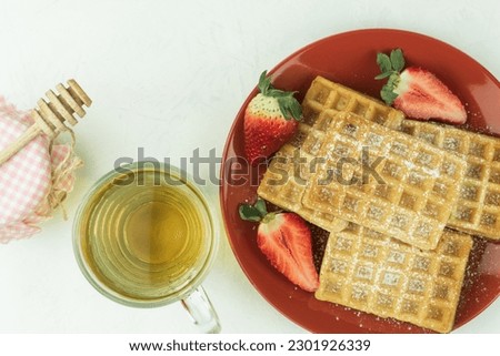 Homemade waffles on a plate for breakfast. A plate with delicious waffles, fruits and berries on a light background