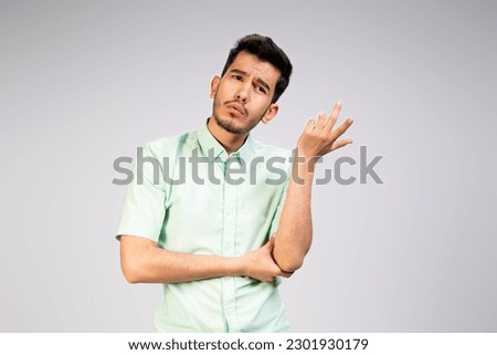 portrait of a young Asian man asking questions with hands raised , thinking about something wearing white shirt isolated on white background Royalty-Free Stock Photo #2301930179