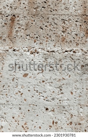 Grunge texture close up. Old damaged stone wall background. Fragment of a wall with little rocks. Easily add depth and organic texture to your designs. Abstract background.