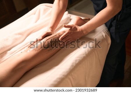 Professional massotherapist giving anti-cellulite massage to patient