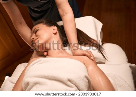 Chiropractor hands doing cervical spine mobilization on female patient