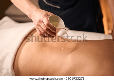 Wellness center massotherapist prepping client for ayurvedic massage