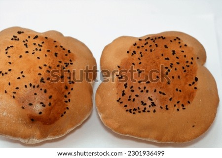Egyptian Mahlab bread, puff thin, crispy and delicious with black seed baraka seeds on top, made of flour, dry yeast, milk, eggs, sugar, salt, black seeds, warm water, with anything or on its own Royalty-Free Stock Photo #2301936499