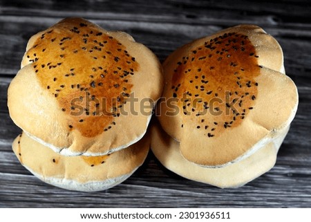Egyptian Mahlab bread, puff thin, crispy and delicious with black seed baraka seeds on top, made of flour, dry yeast, milk, eggs, sugar, salt, black seeds, warm water, with anything or on its own Royalty-Free Stock Photo #2301936511