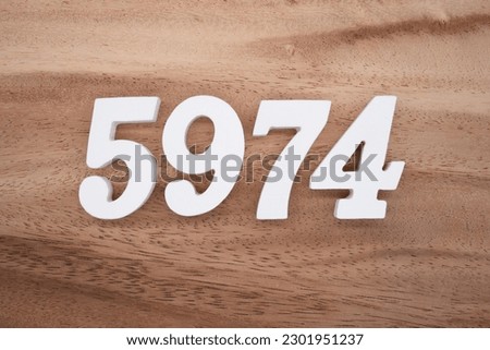 White number 5974 on a brown and light brown wooden background.