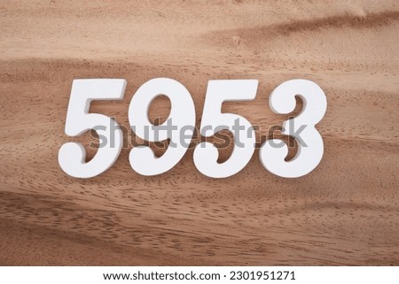 White number 5953 on a brown and light brown wooden background.