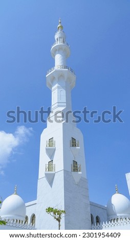 Minaret of Sheikh Zayed Grand Mosque with blue sky on background. Islamic background mosque. Mosque design in Islamic religious architectural traditions. Creative abstract photography
