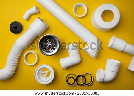 plumbing pvc plastic drain parts on yellow background. top view Royalty-Free Stock Photo #2301955385
